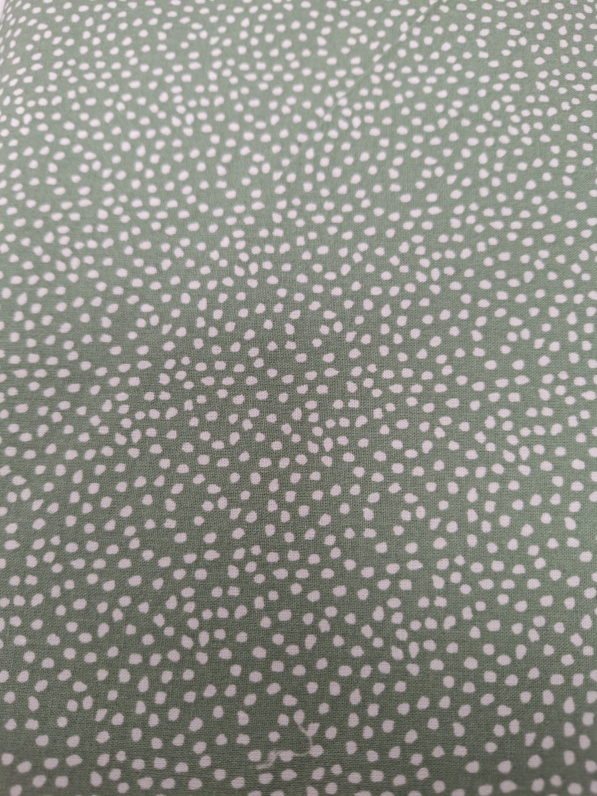 Speelse katoenen stof in groen met witte stippenprint. OEKO-TEX Standard 100 gecertificeerd en ideaal voor kleding, accessoires en woondecoratie.