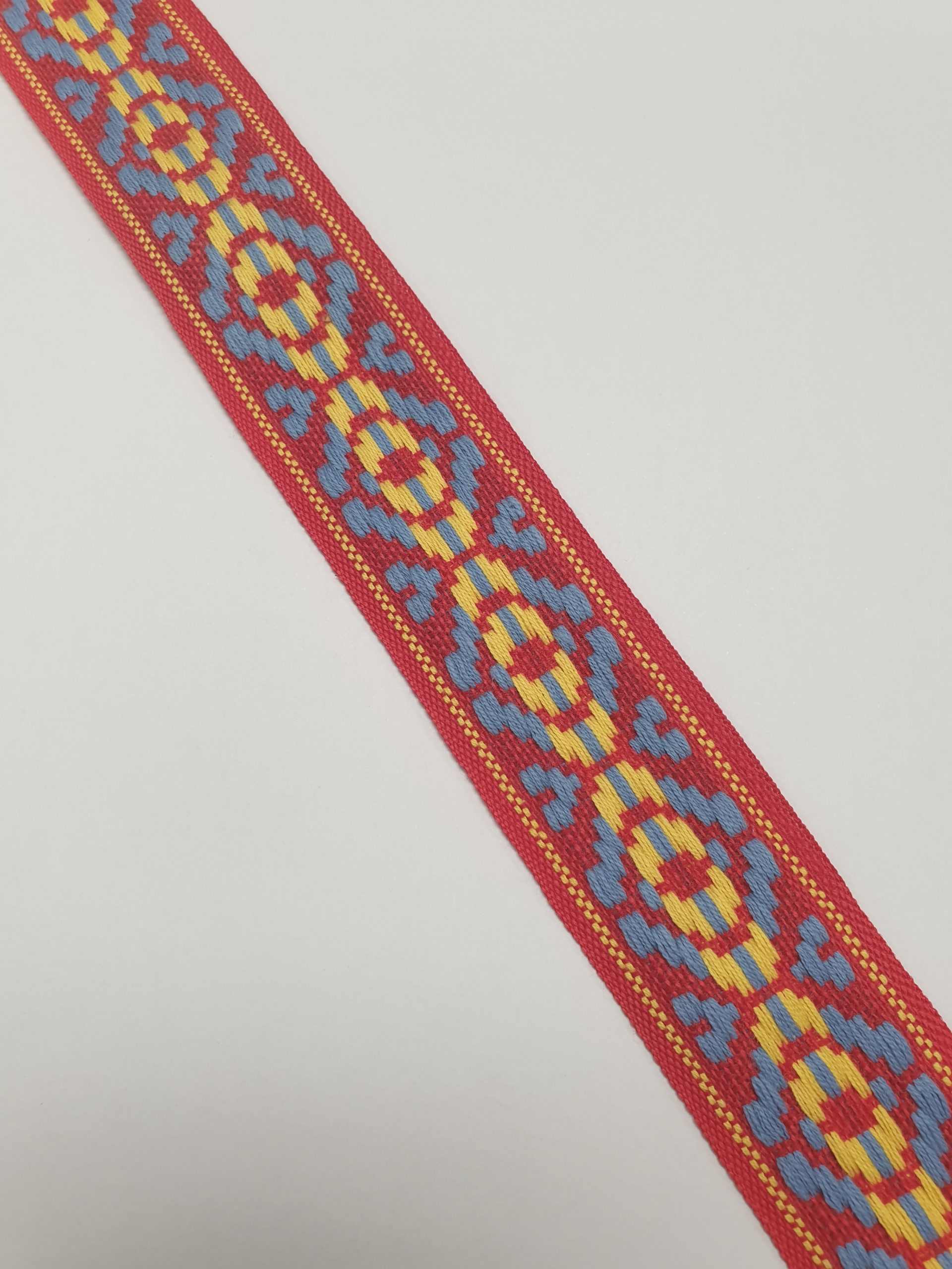 Indianenband rood van 35 mm breed met een decoratief geometrisch patroon. Perfect voor kleding, tassen en creatieve hobbyprojecten.